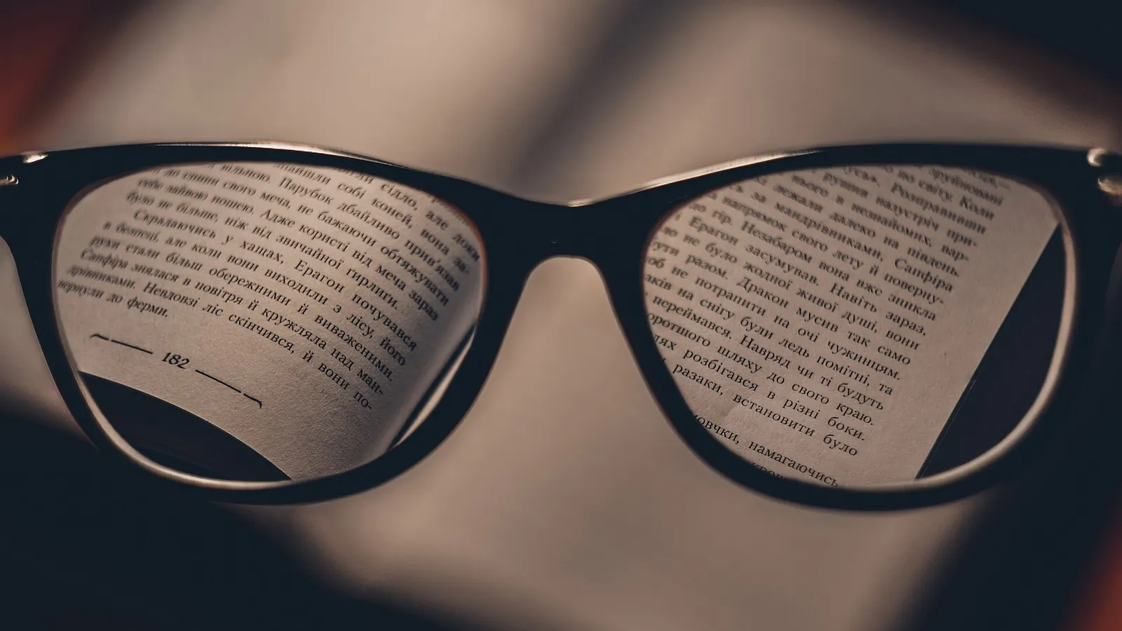 Reading glasses resting over an open book